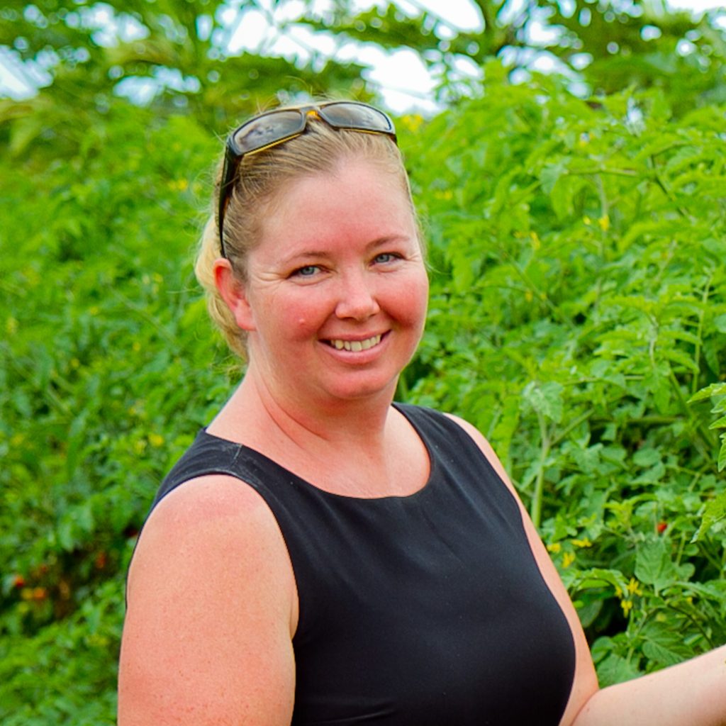 Aletha Thomas of Monkeypod Jam in front of green bushes